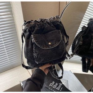 Detail der grauen Vintage-Jeansbeuteltasche mit Kordelzug, Waschung und Goldknopf