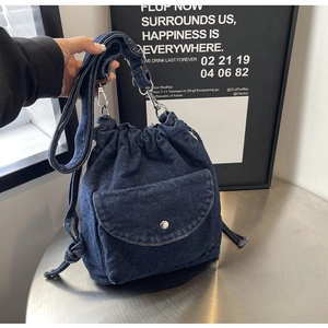 Detailansicht der dunkelblauen Denim-Beuteltasche mit Kordelzug und Silberbeschlägen
