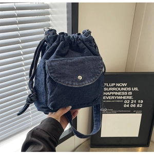 Detail der blauen Denim-Beuteltasche mit silbernem Metallverschluss und Fronttasche