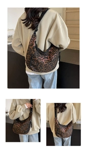 Detailed view of leopard print canvas crossbody bag with adjustable wide strap and zipper detail
