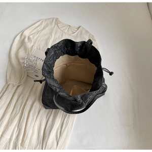Detailed interior of black jacquard tote bag with beige lining and zip pocket