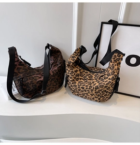 Detail of leopard print crescent bags in brown and tan with adjustable straps
