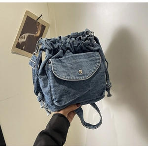 Detail der blauen Jeans-Beuteltasche mit Kordelzug und vorderer Klappentasche