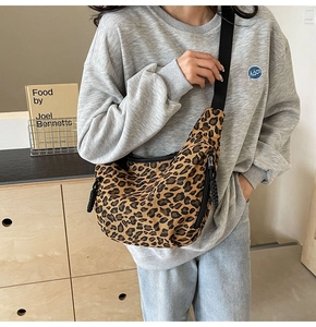 Detail shot of leopard print canvas crescent bag with wide adjustable shoulder strap