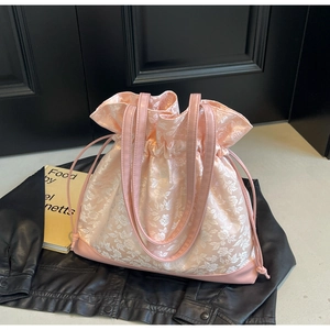 Detail of pink floral jacquard tote bag with drawstring closure and leather handle