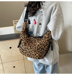 Detail of leopard print canvas crescent bag showing thick rope zipper and wide strap