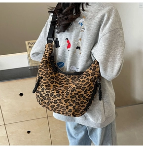 Detailed close-up showing leopard print canvas texture and black adjustable shoulder strap
