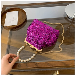 Detail der lila Pailletten-Tasche mit Perlenkap Griff und goldener Kettenriemen