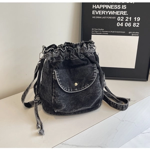 Detail des anthrazitgrauen Denim-Rucksacks mit Kordelzug und Tasche mit Druckknopf