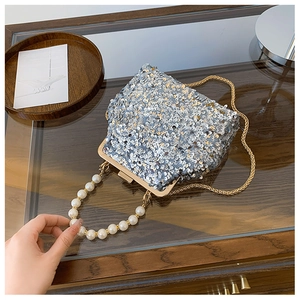 Detailansicht der silbernen Pailletten-Abendtasche mit Perlengriff und Goldkette