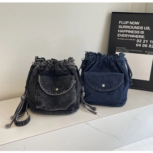 Detail von Denim-Beuteltaschen in Schwarzgrau und Blau mit Metallschnallen