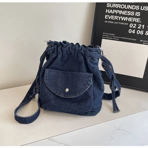 Detailaufnahme der dunkelblauen Denim Beuteltasche mit silberner Schnalle und Kordelzug