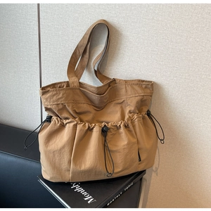 Detailed close-up of khaki ruched tote bag with black drawstring and adjustable buckle