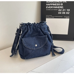 Detail der blauen Denim-Beuteltasche mit Kordelzug, Fronttasche und Metallschnalle