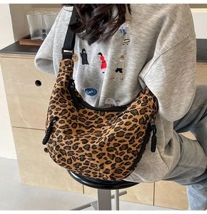 Detail of leopard print canvas dumpling bag with adjustable black strap and rope zipper