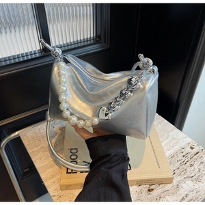 Détail du sac à main argenté avec bandoulière en perles et chaîne de cœur chic