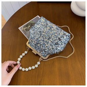 Detailansicht der silbernen Paillettentasche mit elegantem Perlengriff und goldener Kette