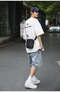Detailed view of model wearing a stylish black crossbody bag with multiple compartments