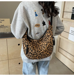 Detailed view of the leopard print canvas dumpling bag with adjustable shoulder strap