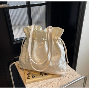 Detail of cream floral jacquard tote bag with drawstring closure and leather base