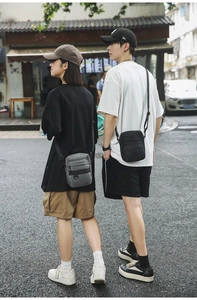 Outdoor street view of durable black and grey nylon crossbody bags with adjustable straps