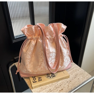 Detail of floral jacquard satin tote bag with pink leather trim and drawstring closure