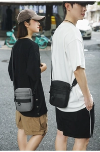 Macro detail of compact crossbody bags in black and grey with adjustable shoulder straps
