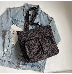 Detail der Canvas-Einkaufstasche mit Leopardenmuster und Vordertaschen auf Denim