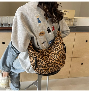 Detailed close-up of leopard print canvas crescent bag with braided zipper pull detail