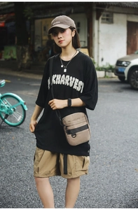 Detail of khaki crossbody bag with multiple zip compartments and durable nylon fabric