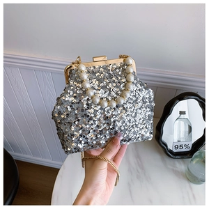 Detail der silbernen Pailletten-Abendtasche mit Perlengriff und Goldkettenriemen