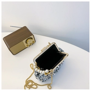 Detailansicht der silbernen Pailletten-Abendtasche mit Perlengriff und Goldkette