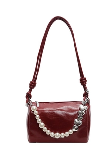 Sac à main rond bordeaux avec chaîne de perles et boucle cœur sur fond blanc
