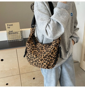 Detail of leopard print hobo bag with black wide strap and stylish zipper closure