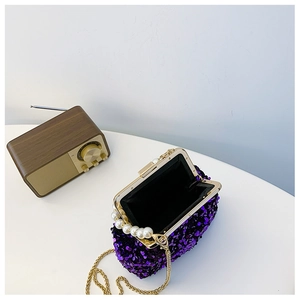 Detail der lila Pailletten-Muscheltasche mit Perlengriff und goldener Kette