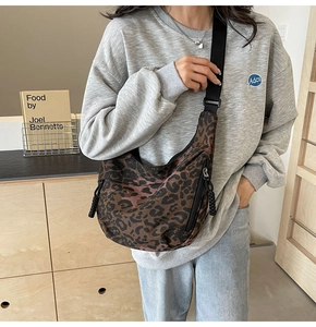 Detail of leopard print crescent bag with adjustable wide strap and side zip pocket