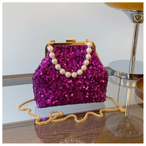 Detailansicht der magentafarbenen Pailletten-Clutch mit Perlengriff und Goldkette