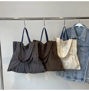 Detailed comparison of canvas tote bags in dark grey, brown, and off-white colors