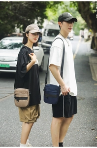Detail of khaki and navy nylon crossbody bags featuring multi-layer storage and D-ring