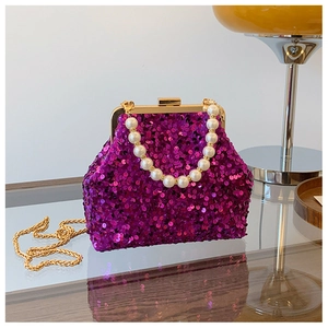 Makro-Detail der fuchsiafarbenen Pailletten-Abendtasche mit Perlenkordel und Goldkette