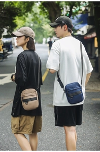Outdoor street view of navy and khaki crossbody bags with adjustable straps