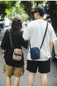 Detailed street style view of khaki and navy nylon crossbody bags with adjustable straps
