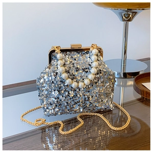 Nahaufnahme der silbernen Pailletten-Abendtasche mit Perlengriff und goldener Kette