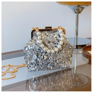 Makro-Detail der Pailletten-Abendtasche mit Perlengriff und goldener Kette