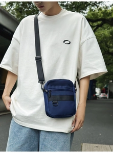 Detail of dark blue waterproof nylon crossbody bag with D-ring and adjustable strap
