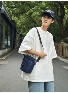 Close-up of a navy blue multi-pocket crossbody bag with adjustable wide shoulder strap