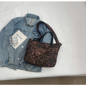 Close-up of leopard print canvas tote bag with black handles and wide shoulder strap