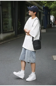 Detailed street style view of multi-pocket black nylon crossbody bag for men