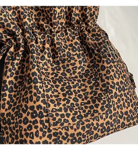Detail of leopard print canvas bag showing drawstring closure and fabric texture