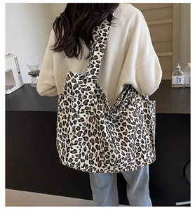 Dettaglio della grande borsa tote in tela leopardata con tracolla larga per il trasporto